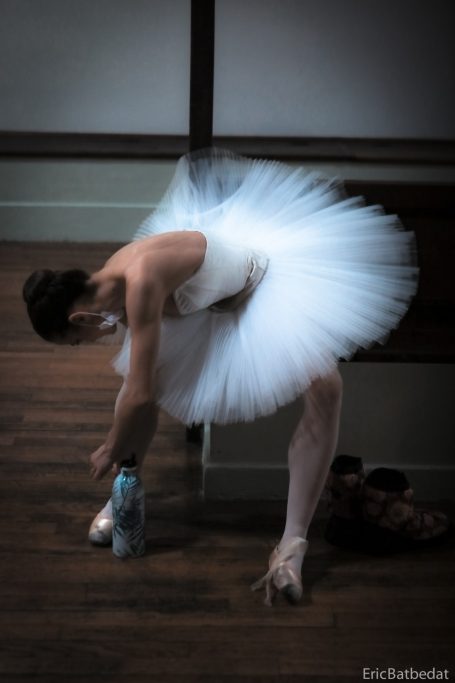 La danseuse Une ballerine en tutu ajuste ses pointes dans un studio de danse.