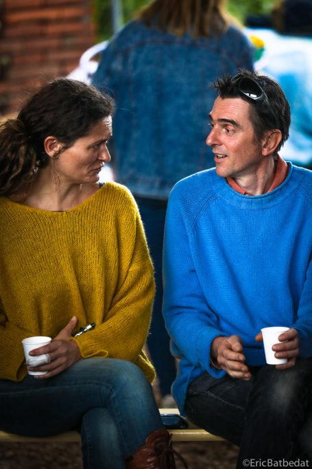 Portrait adultes Deux personnes souriant et discutant, tenant des gobelets en papier.