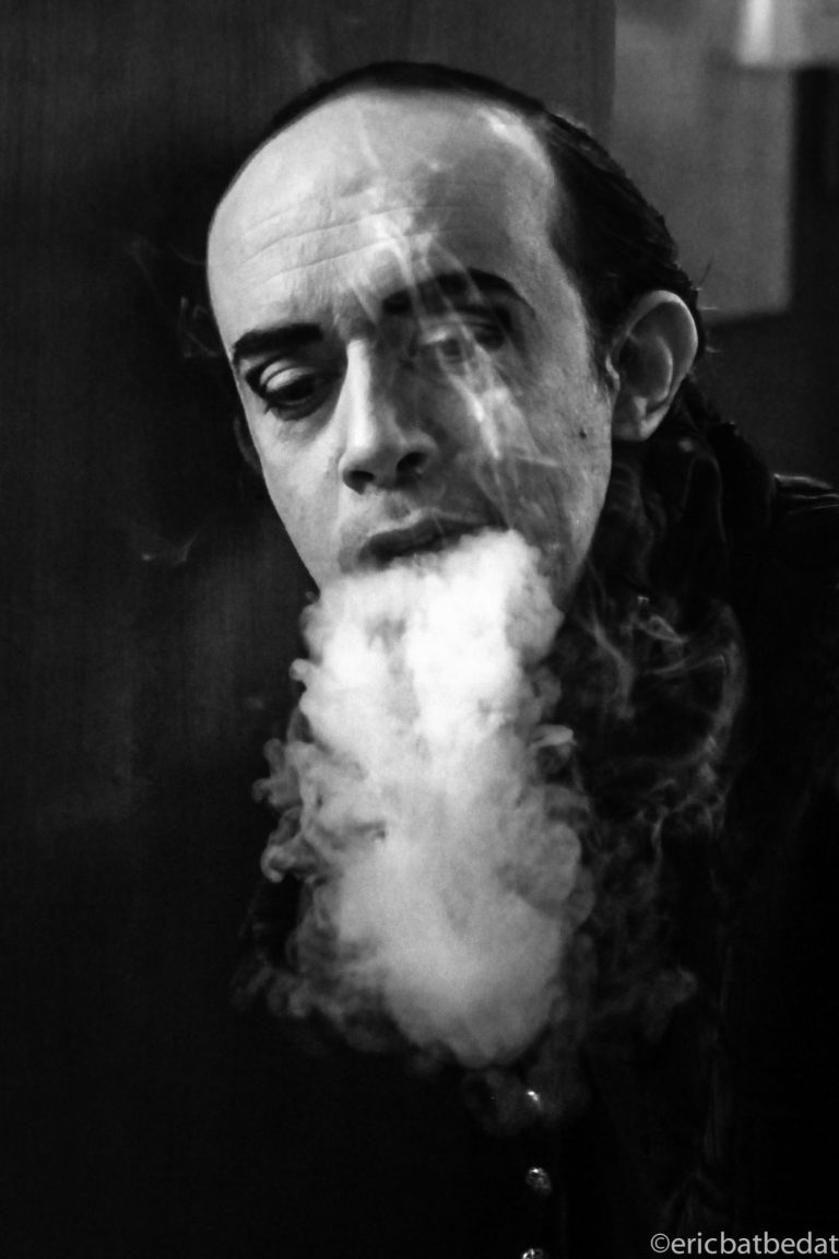 Langue de vapeur Homme avec un visage expressif, fumée s'échappant de sa bouche, en noir et blanc.