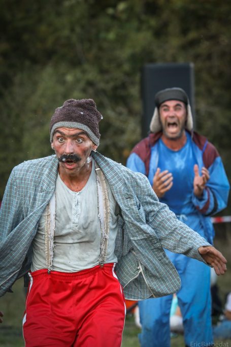 Mariage-couple Une mariée en robe rouge et blanche avec un bouquet, posant avec un marié souriant.