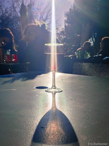 et la lumière fut Un verre à pied sur une table, projetant une ombre allongée et éclairé par la lumière.